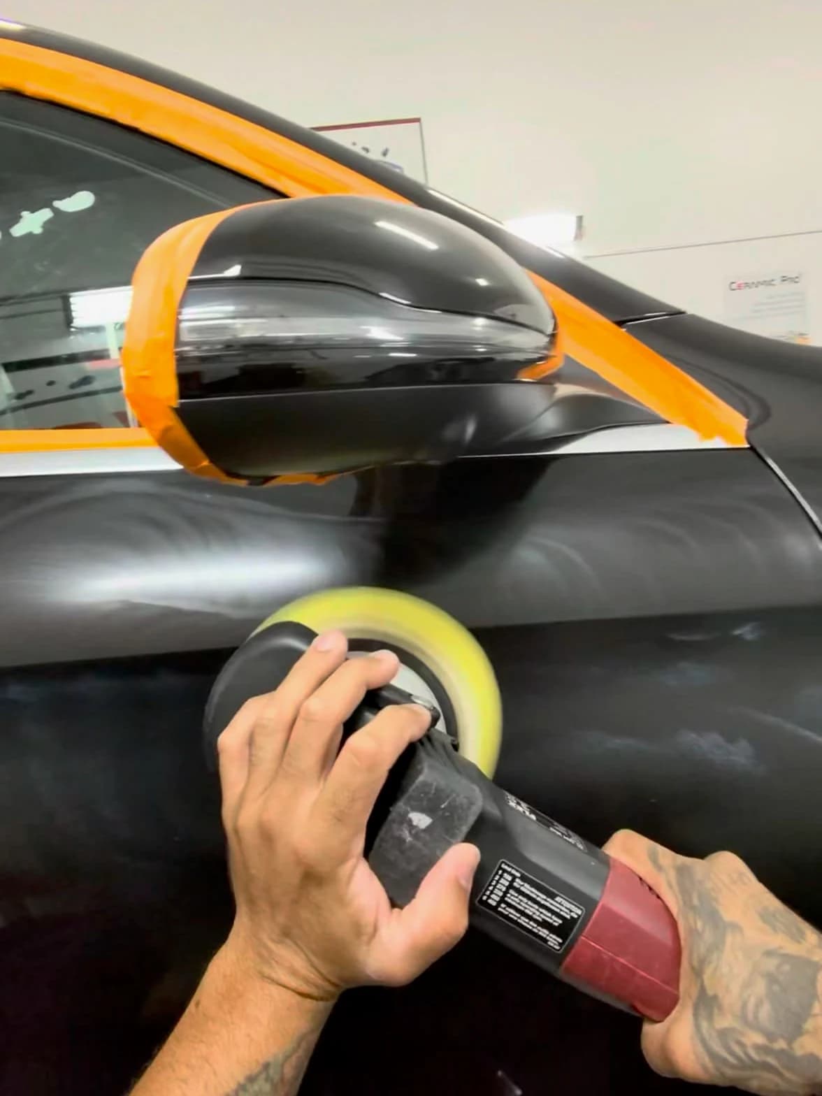 Rod Shine polishing a black vehicle door during paint correction